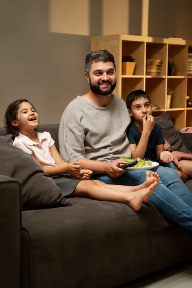 Familie genießt gemeinsam Fernsehen in einem modernen Wohnzimmer